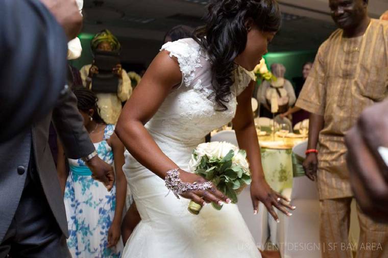 bride dancing and holding bouquet of flowers at clarion hotel wedding in concord california